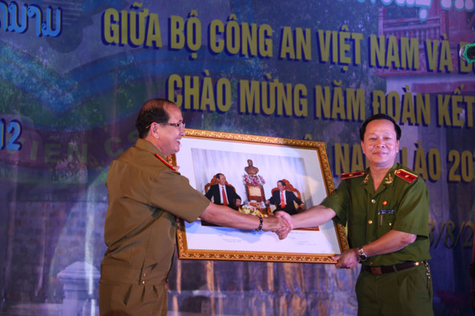 Đồng chí Thiếu tướng GS.TS Nguyễn Xuân Yêm Giám đốc Học viện CSND tặng quà cho đại diện Bộ An ninh Lào - TS Thoong khên Bun mặn, Phó Tổng cục trưởng Tổng cục Chính trị Bộ An ninh Lào